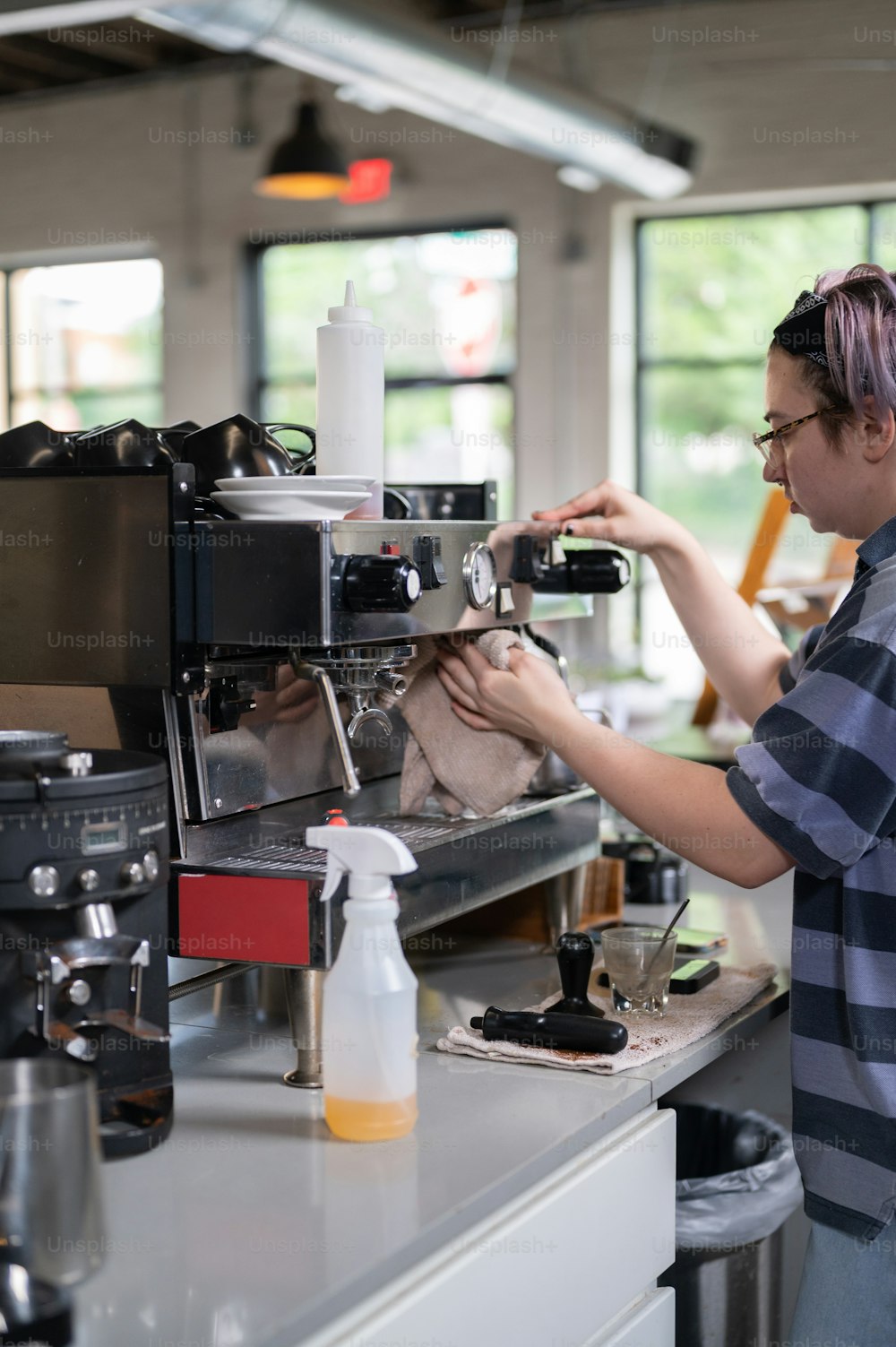 Una donna che lavora su una macchina da caffè in una caffetteria