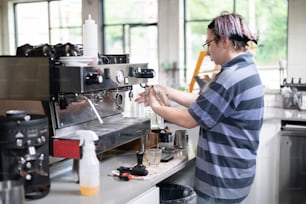 a woman is working on a coffee machine