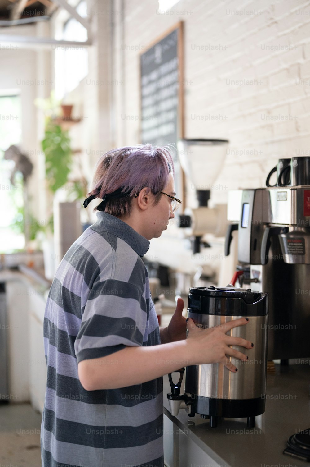 a man with purple hair is using a coffee maker