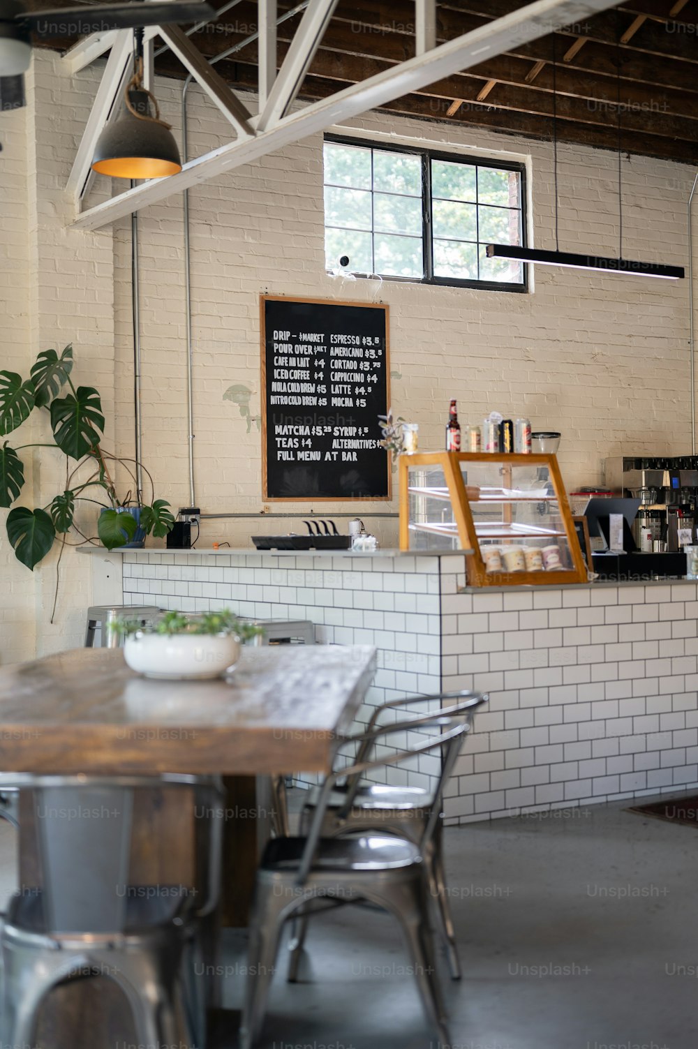 a table and chairs in a room with a menu on the wall