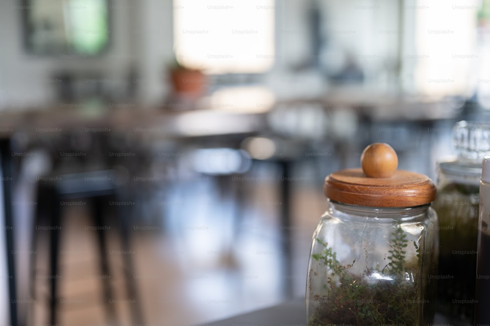 a glass jar filled with moss and a wooden lid