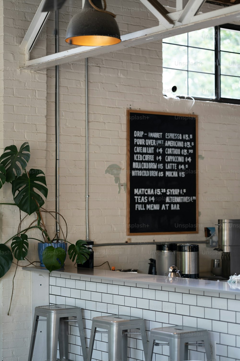 a bar with stools and a chalkboard on the wall