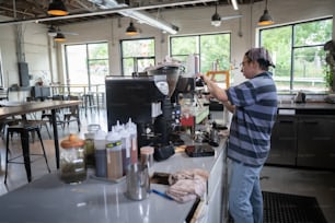 Un hombre parado frente a una cafetera