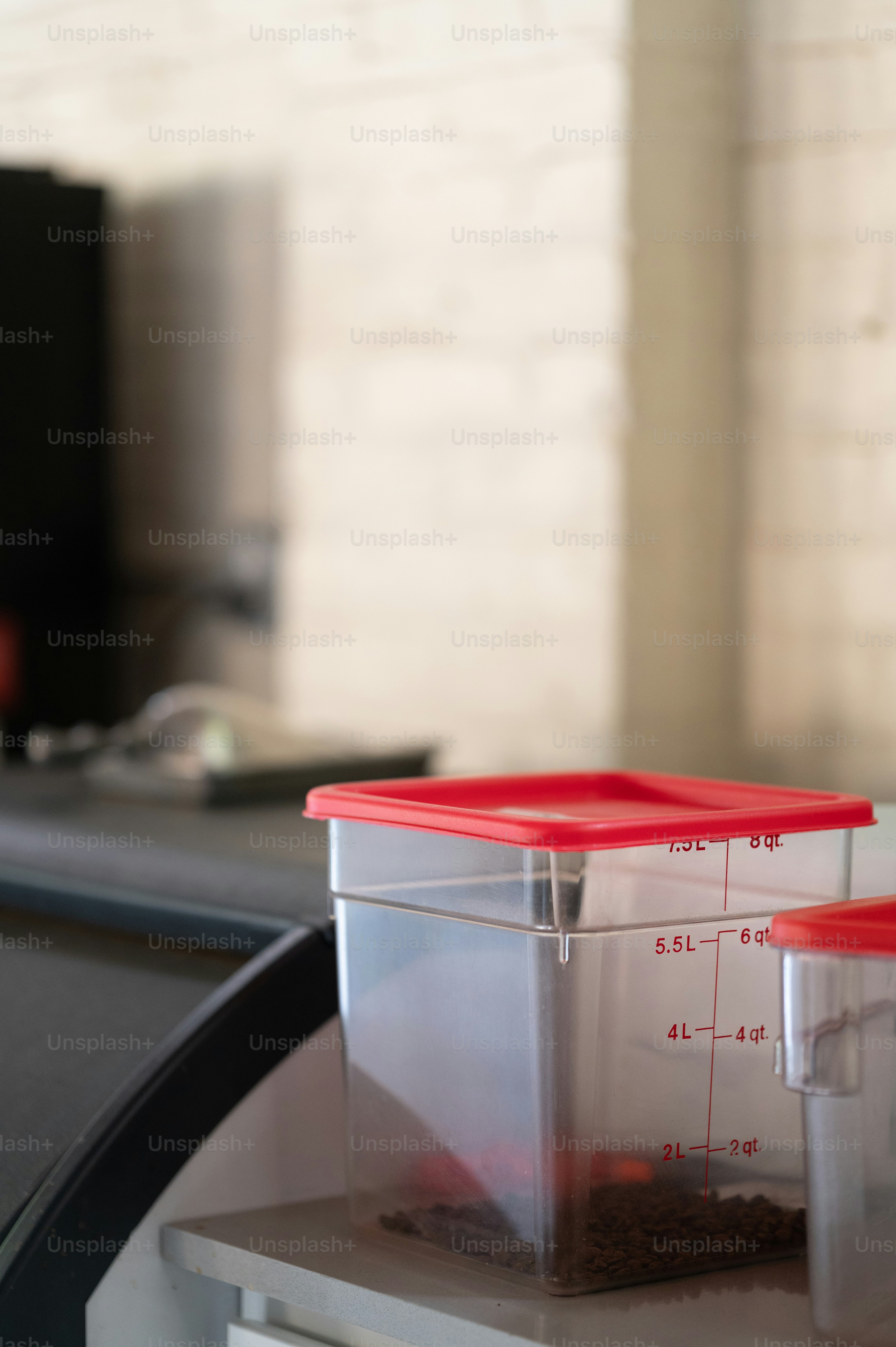 a plastic container with a measuring cup on top of it