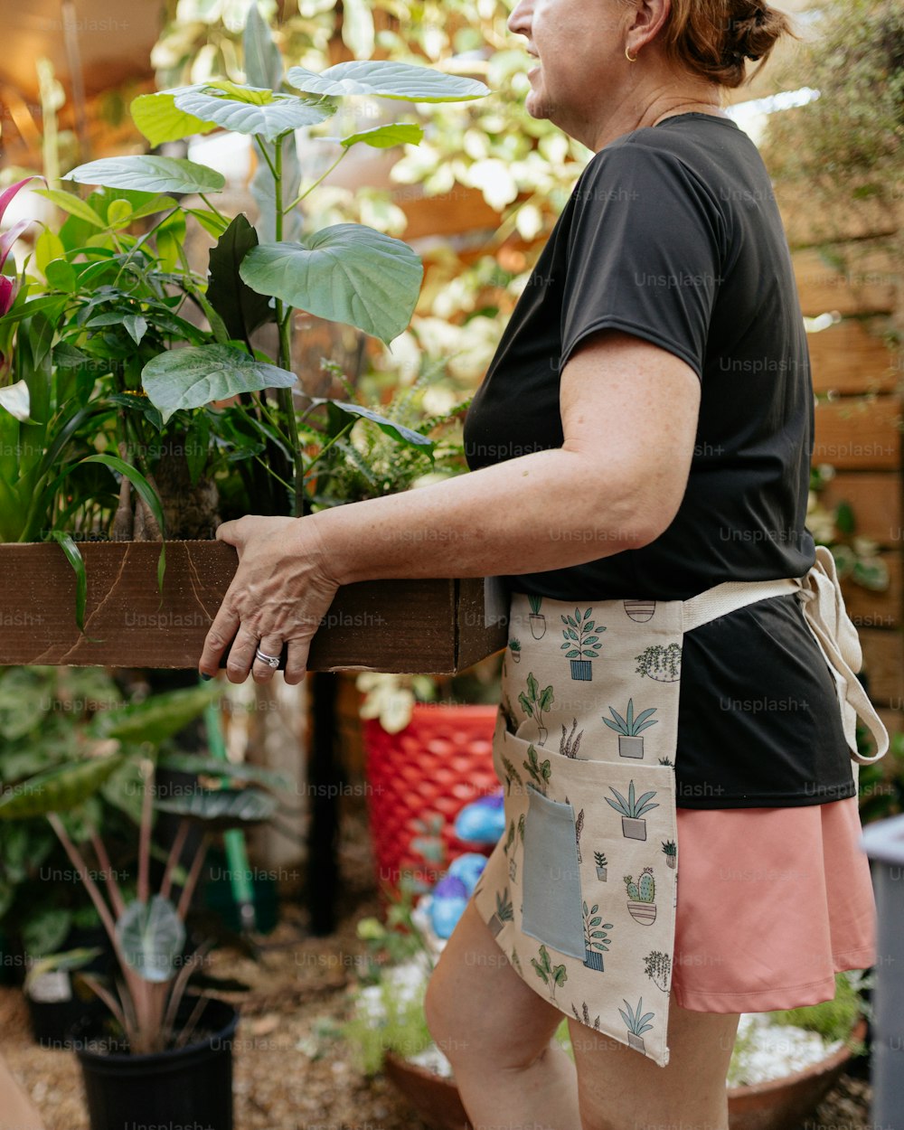 a woman in a black shirt is holding a plant