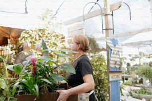 Una mujer sosteniendo una caja llena de plantas