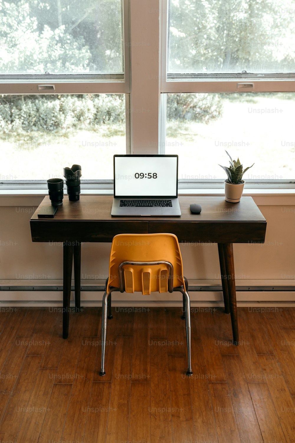 un computer portatile seduto sopra una scrivania di legno