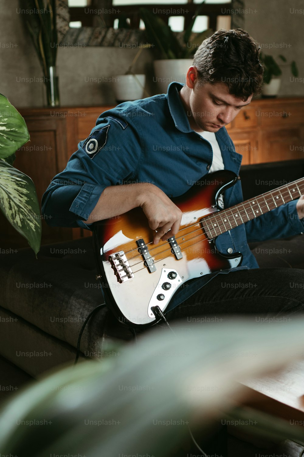 Un uomo seduto su un divano che suona una chitarra