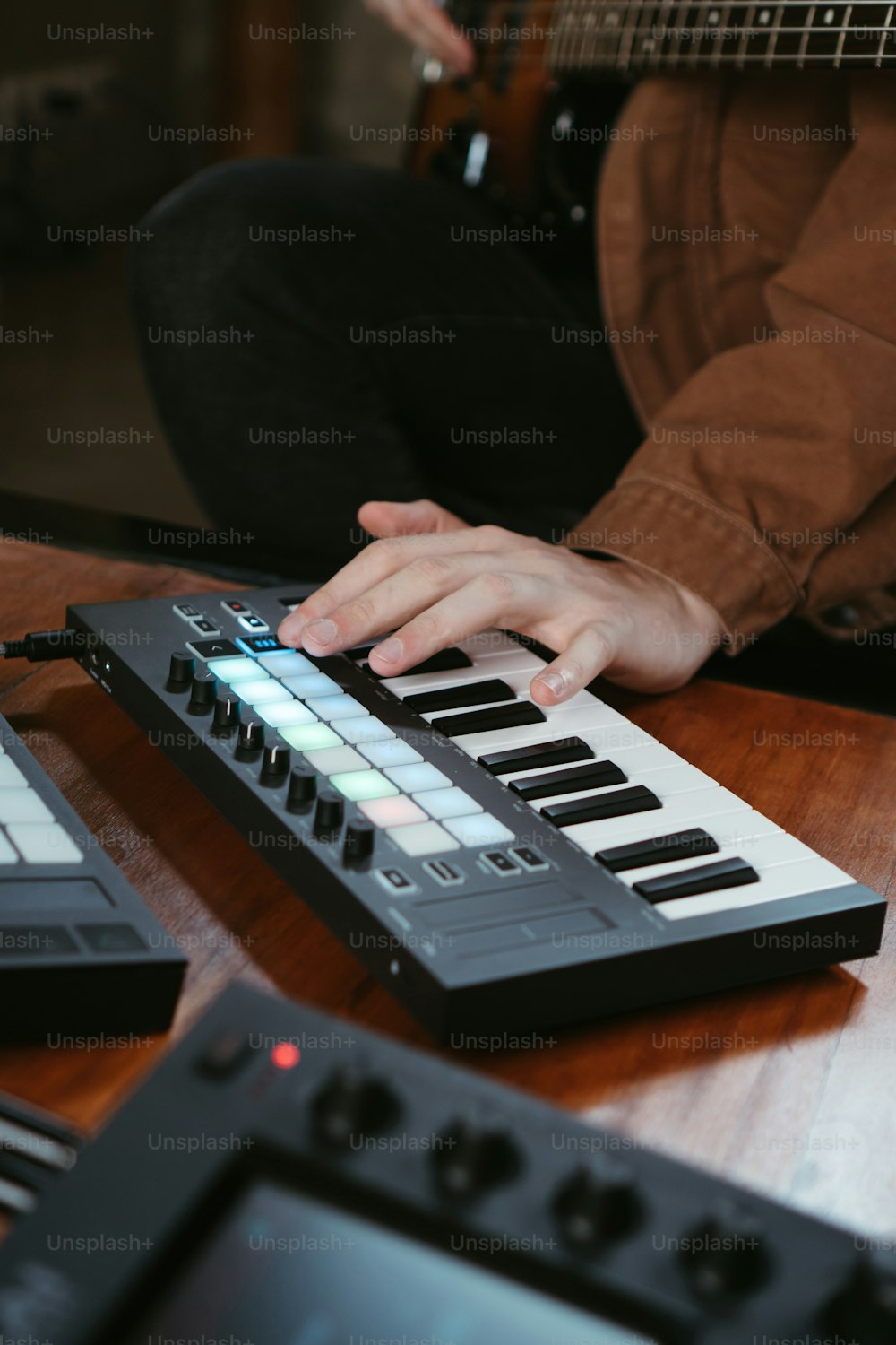 uma pessoa tocando um teclado eletrônico em uma mesa