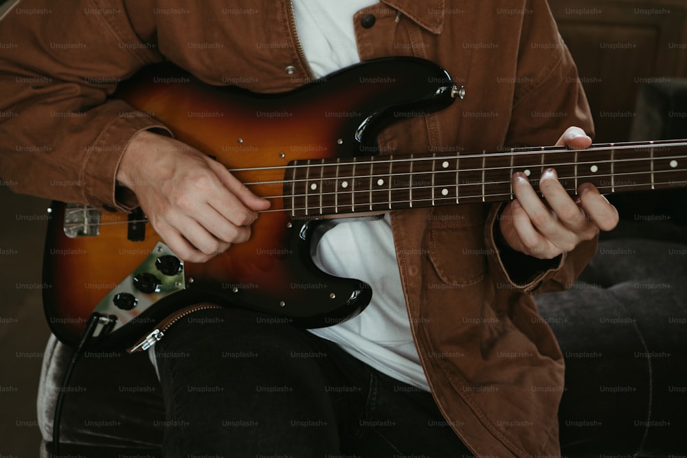 a man playing a guitar while sitting down