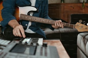 a man sitting on a couch playing a guitar