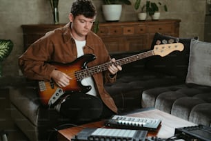 a man sitting on a couch playing a guitar