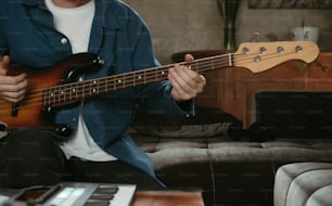 a man sitting on a couch playing a guitar