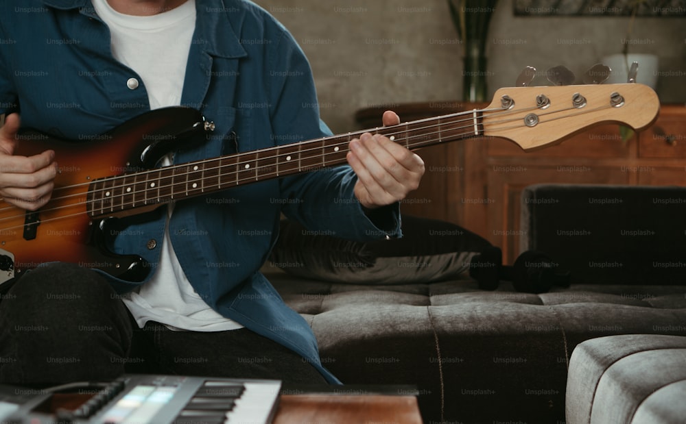 a man sitting on a couch playing a guitar