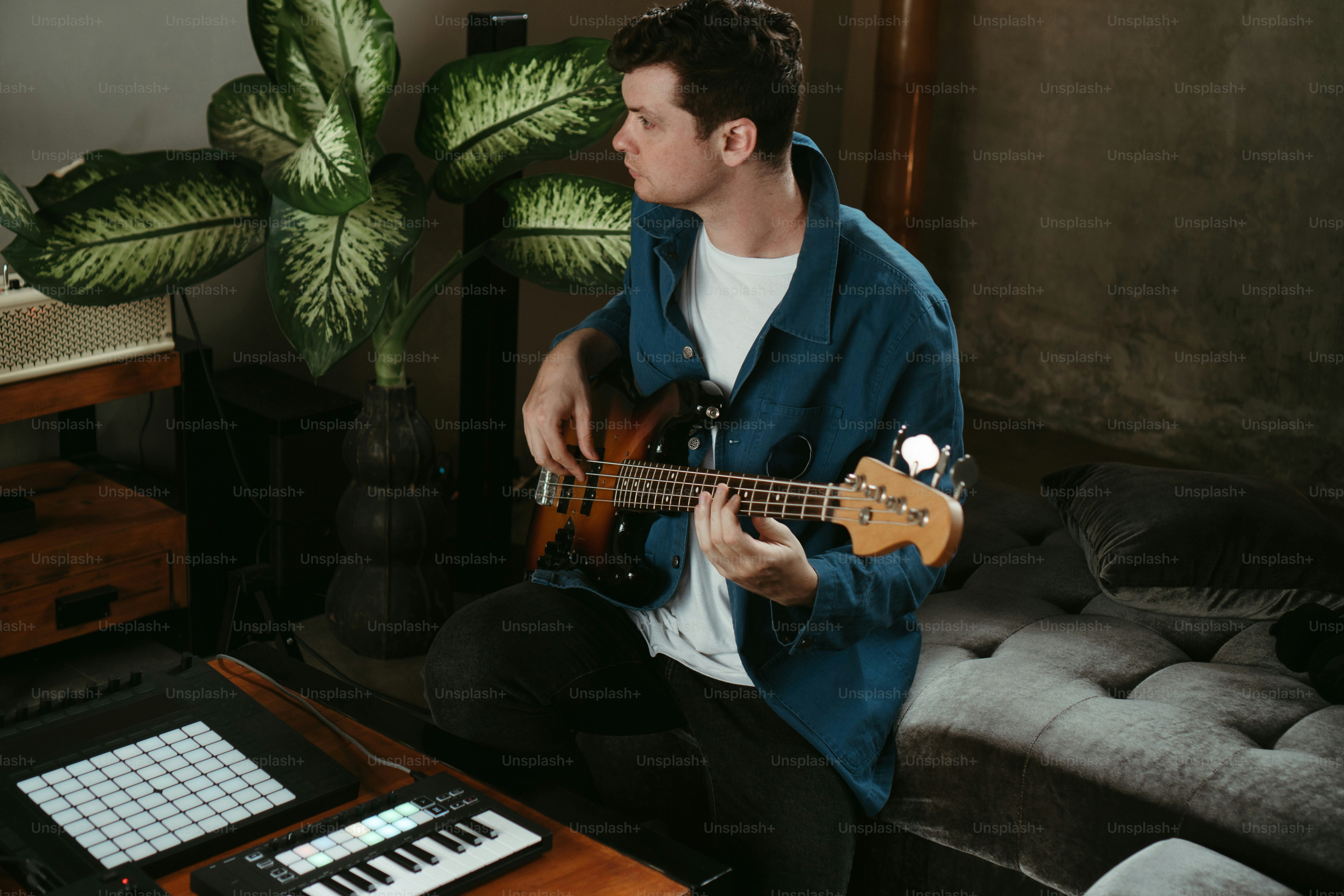 a man sitting on a couch playing a guitar