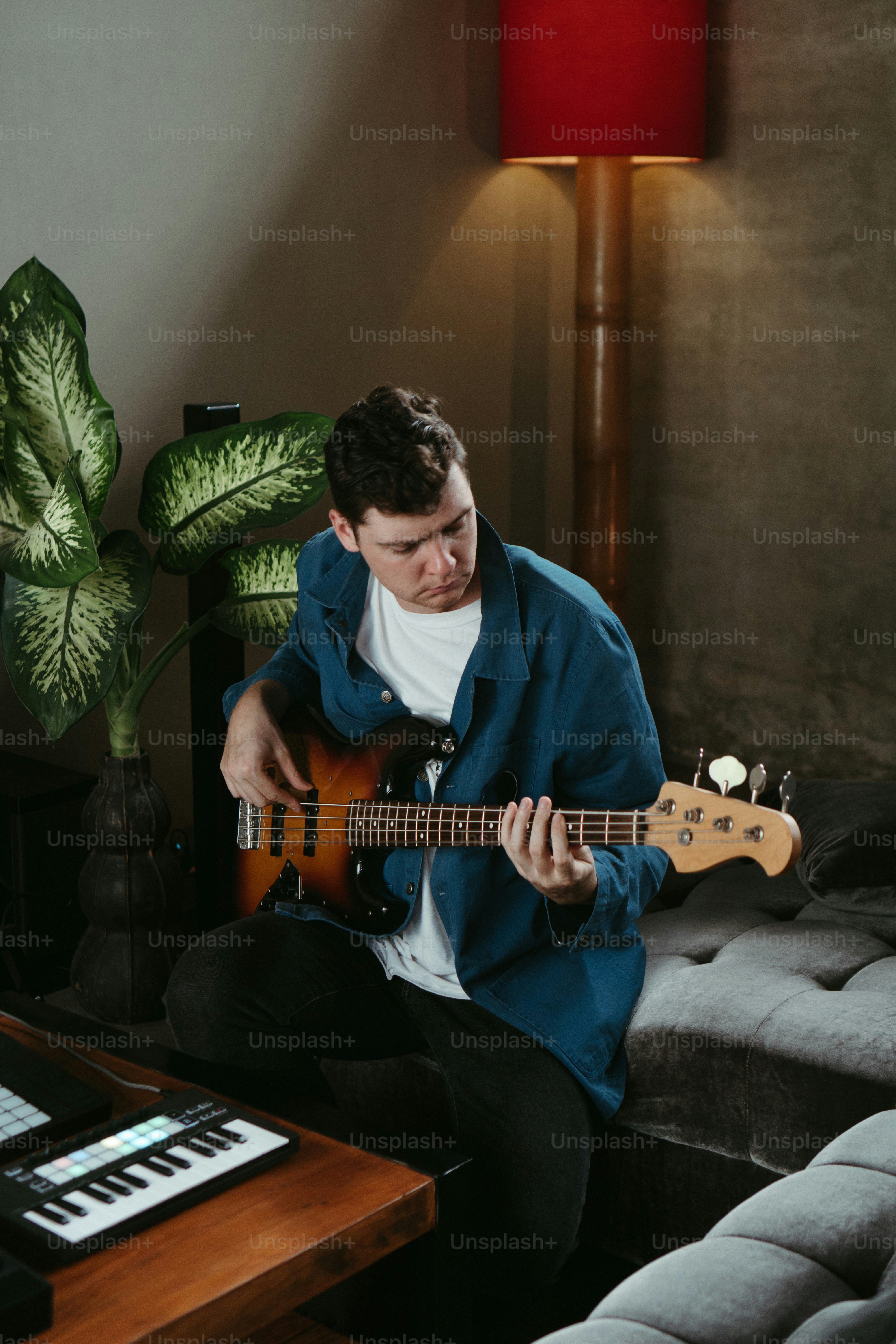 a man sitting on a couch playing a guitar