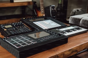 a wooden table topped with electronic equipment and a guitar