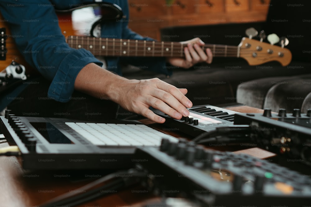 a person playing a keyboard with a guitar in the background