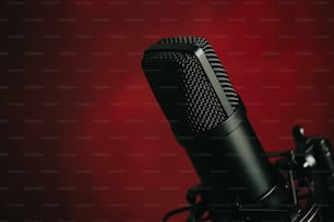 Un micrófono negro con fondo rojo