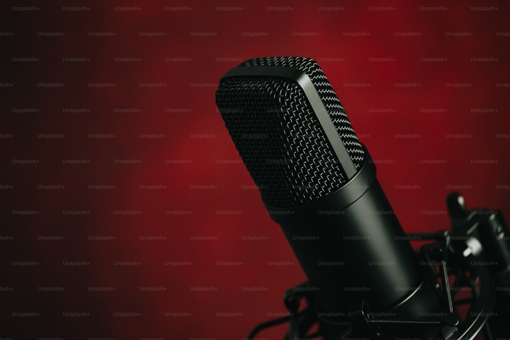 Un micrófono negro con fondo rojo