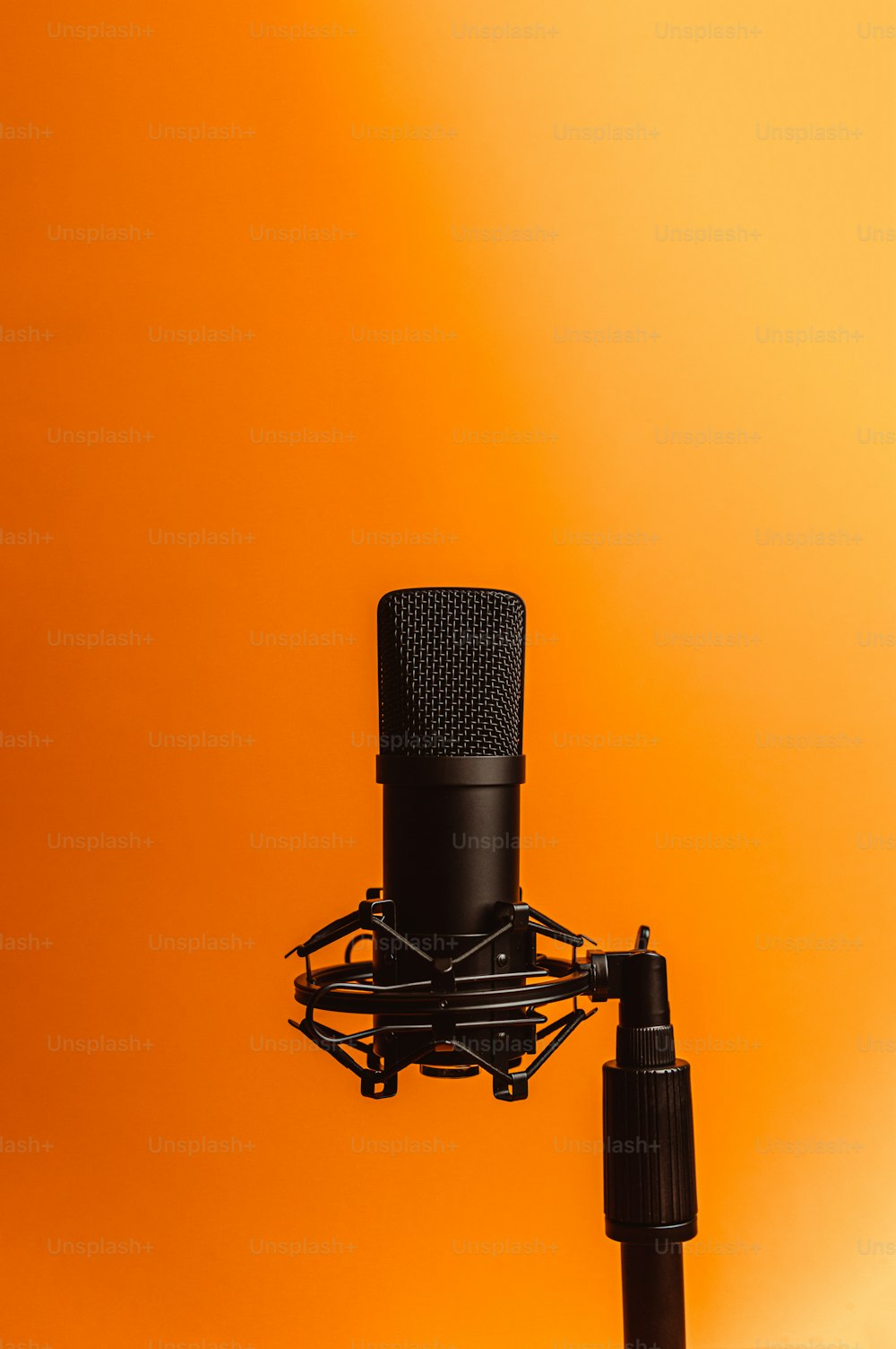 ein schwarzes Mikrofon auf gelbem Hintergrund