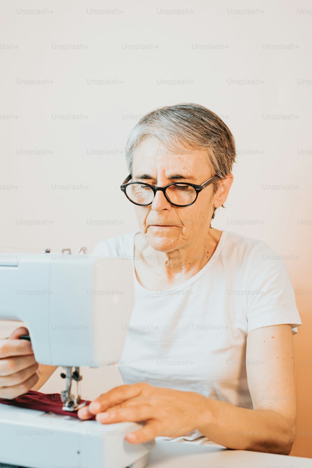 Eine ältere Frau benutzt eine Nähmaschine
