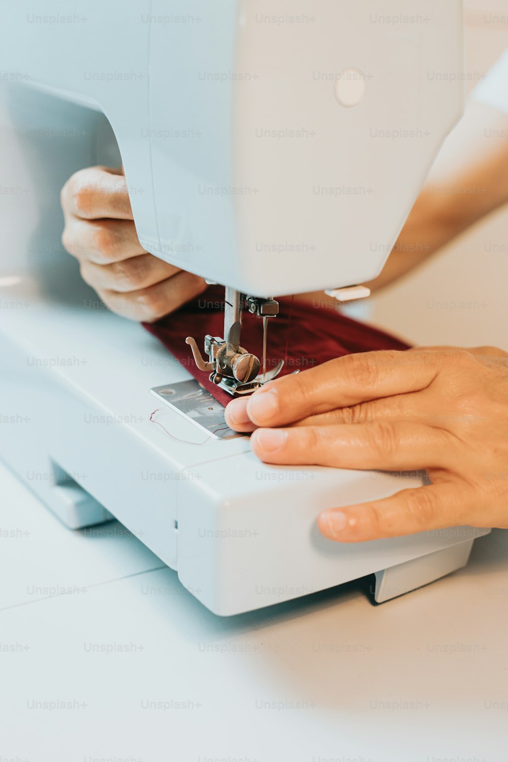 una persona che usa una macchina da cucire per cucire un pezzo di tessuto