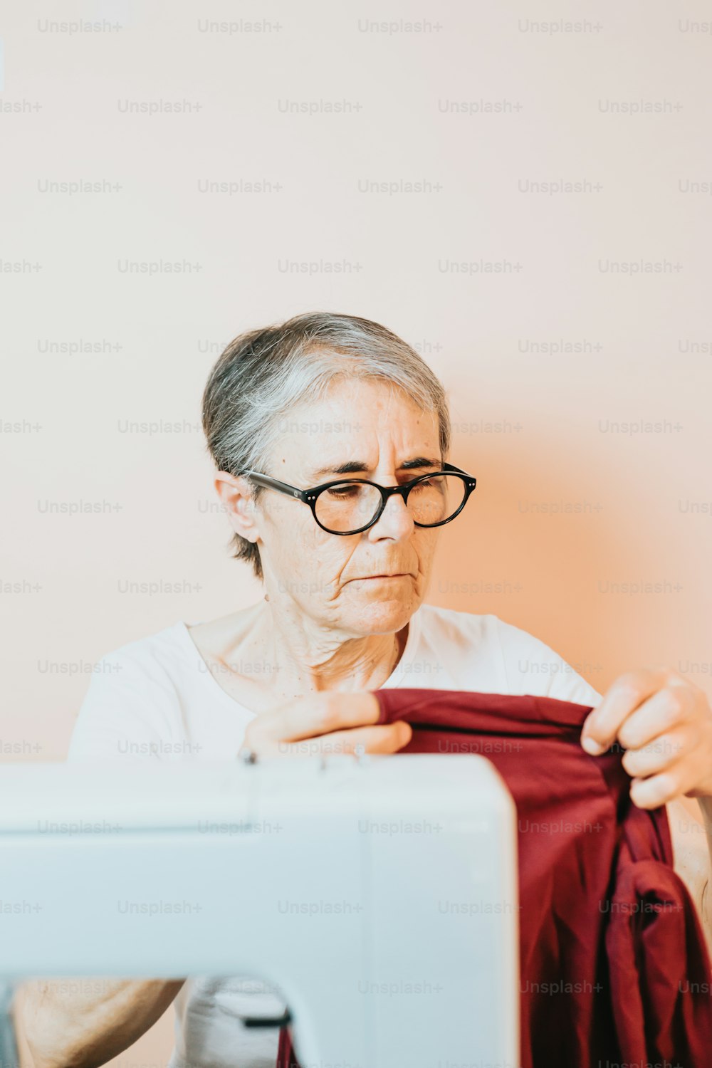 나이 든 여자가 재봉틀로 바느질을 하고 있다