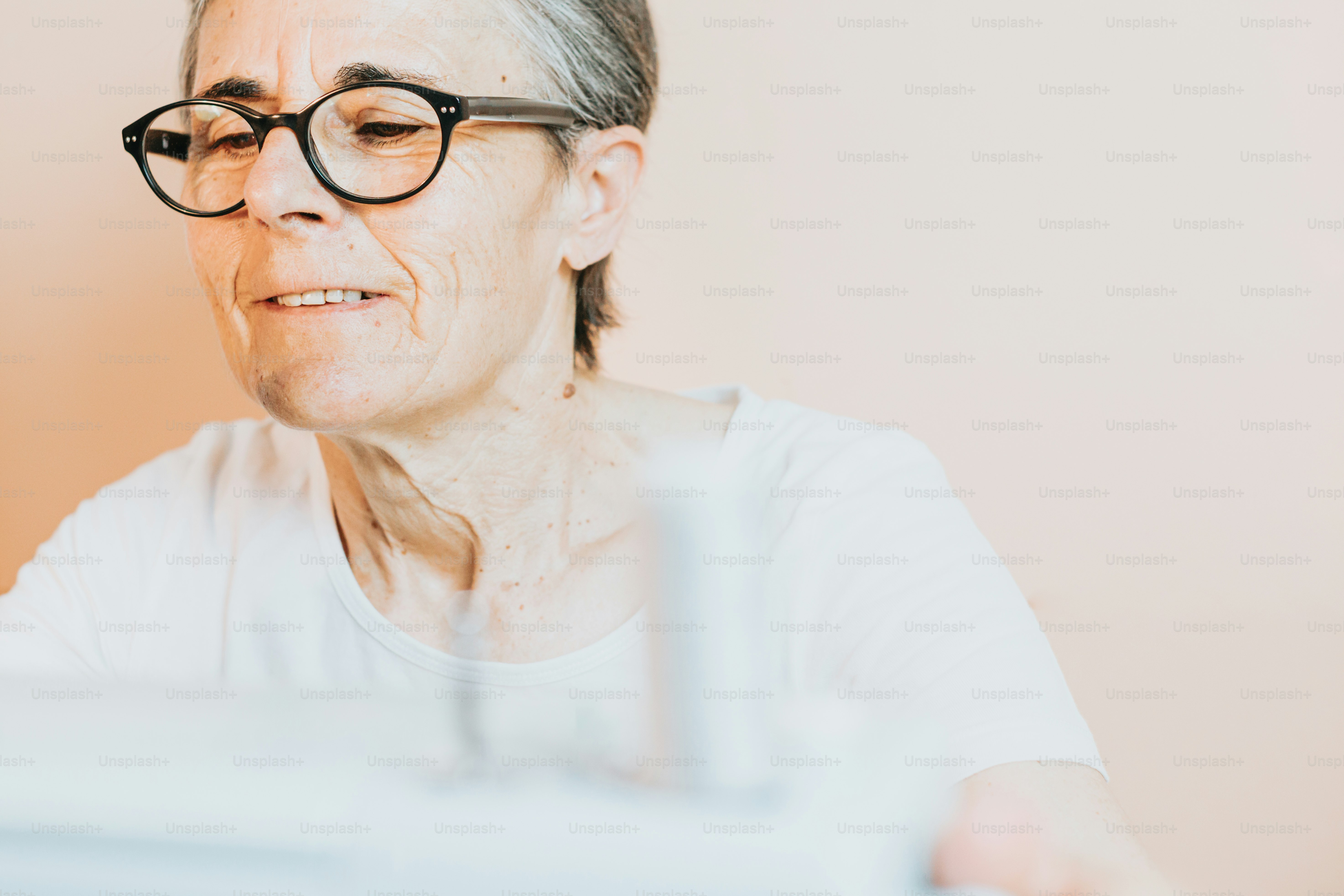 an older woman wearing glasses looking at the camera