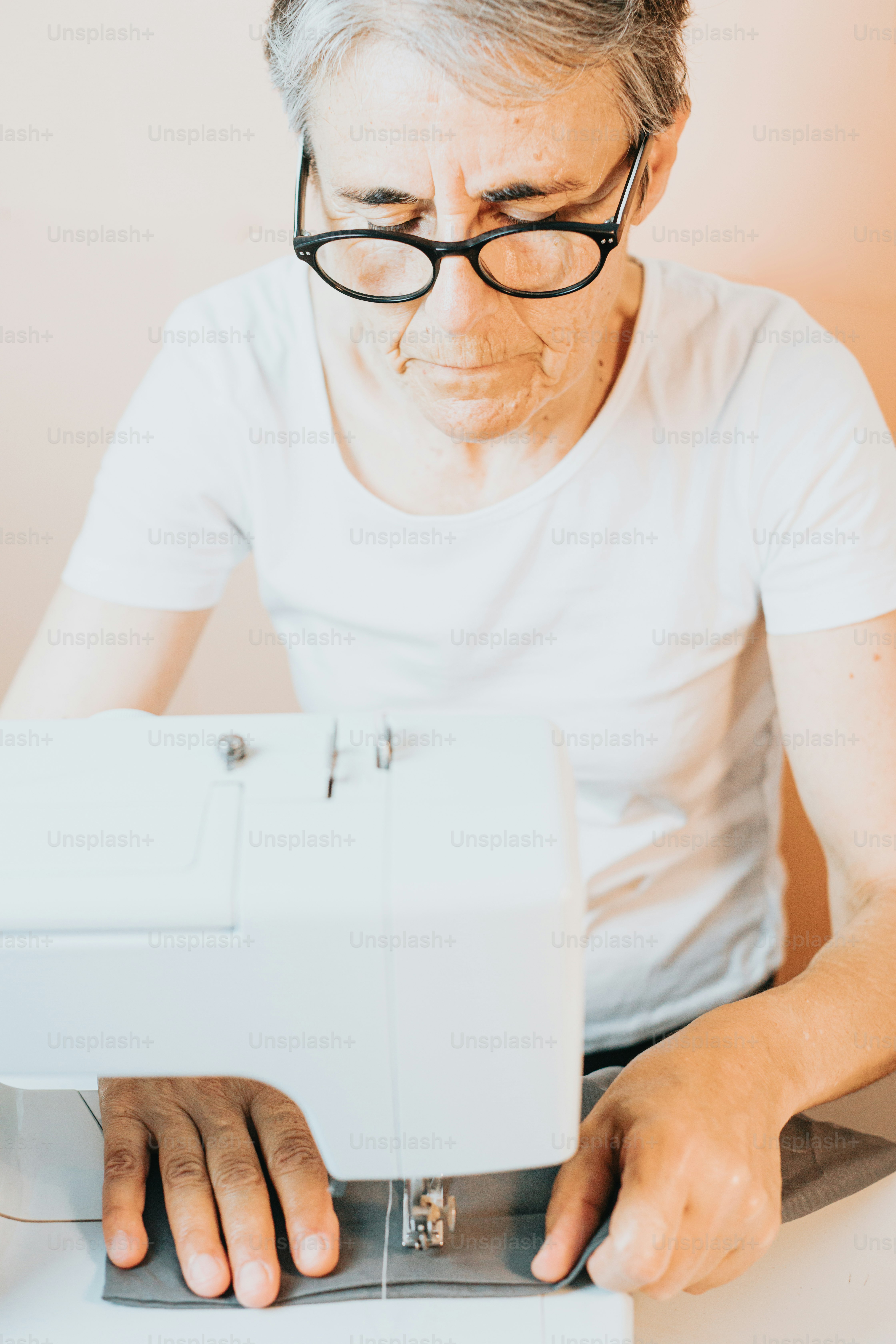 an older woman is using a sewing machine
