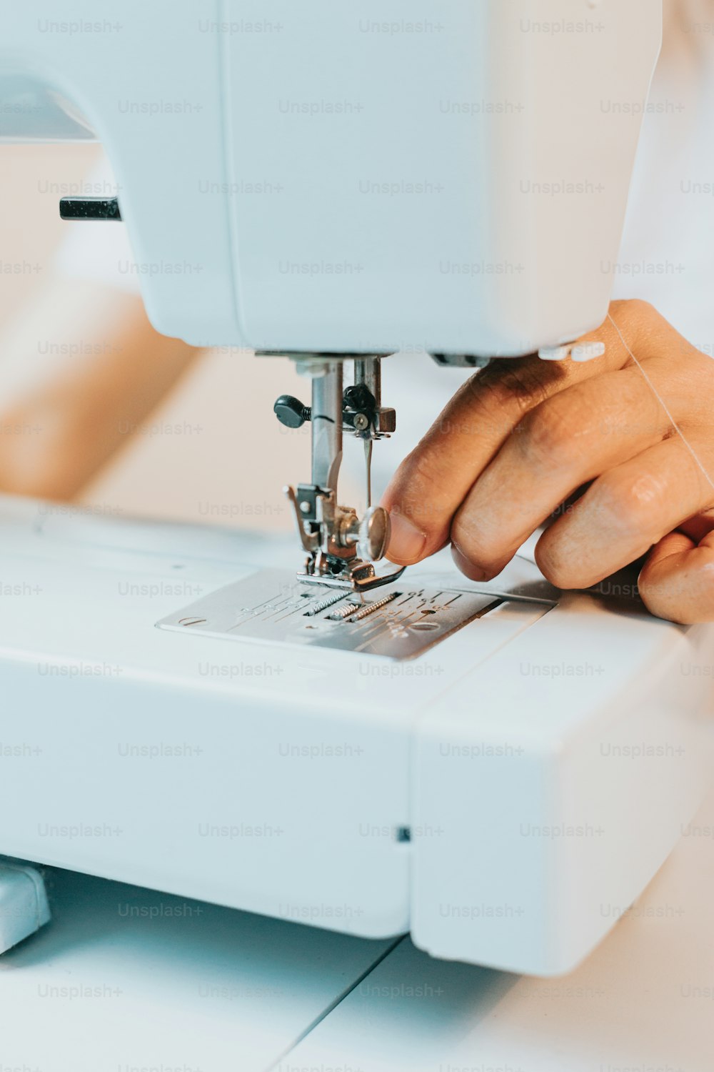 a close up of a person using a sewing machine