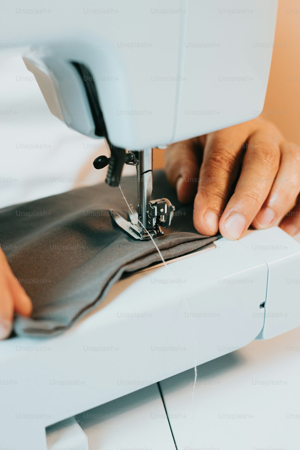 uma pessoa usando uma máquina de costura para costurar um pedaço de pano