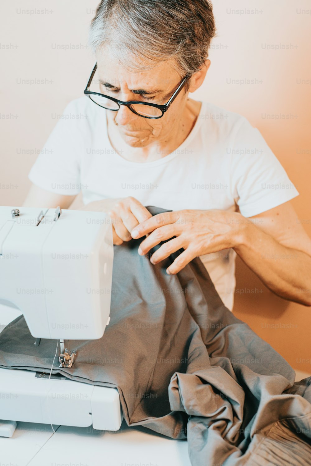 Um homem está trabalhando em uma máquina de costura