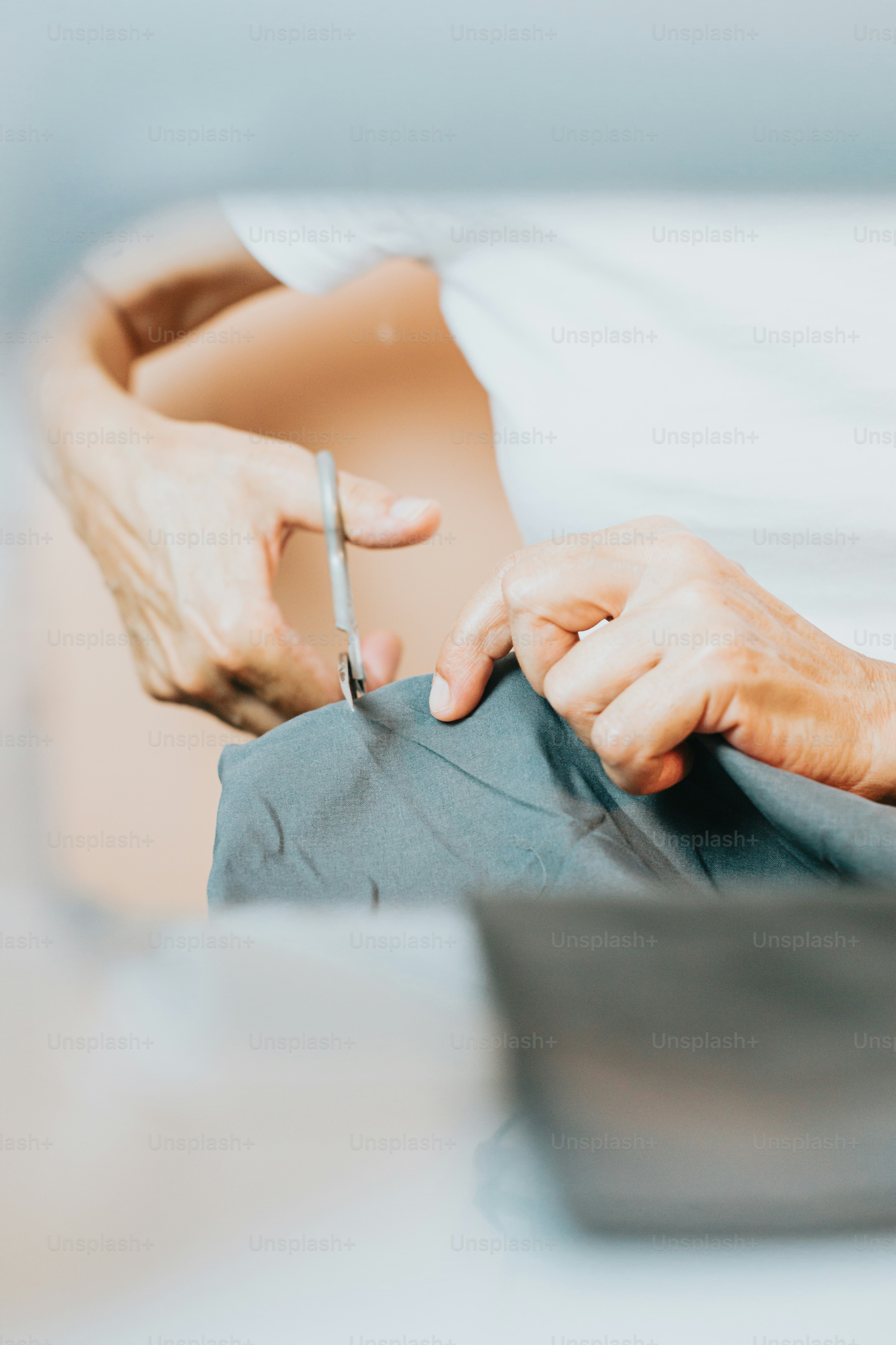 a person cutting a piece of cloth with a pair of scissors