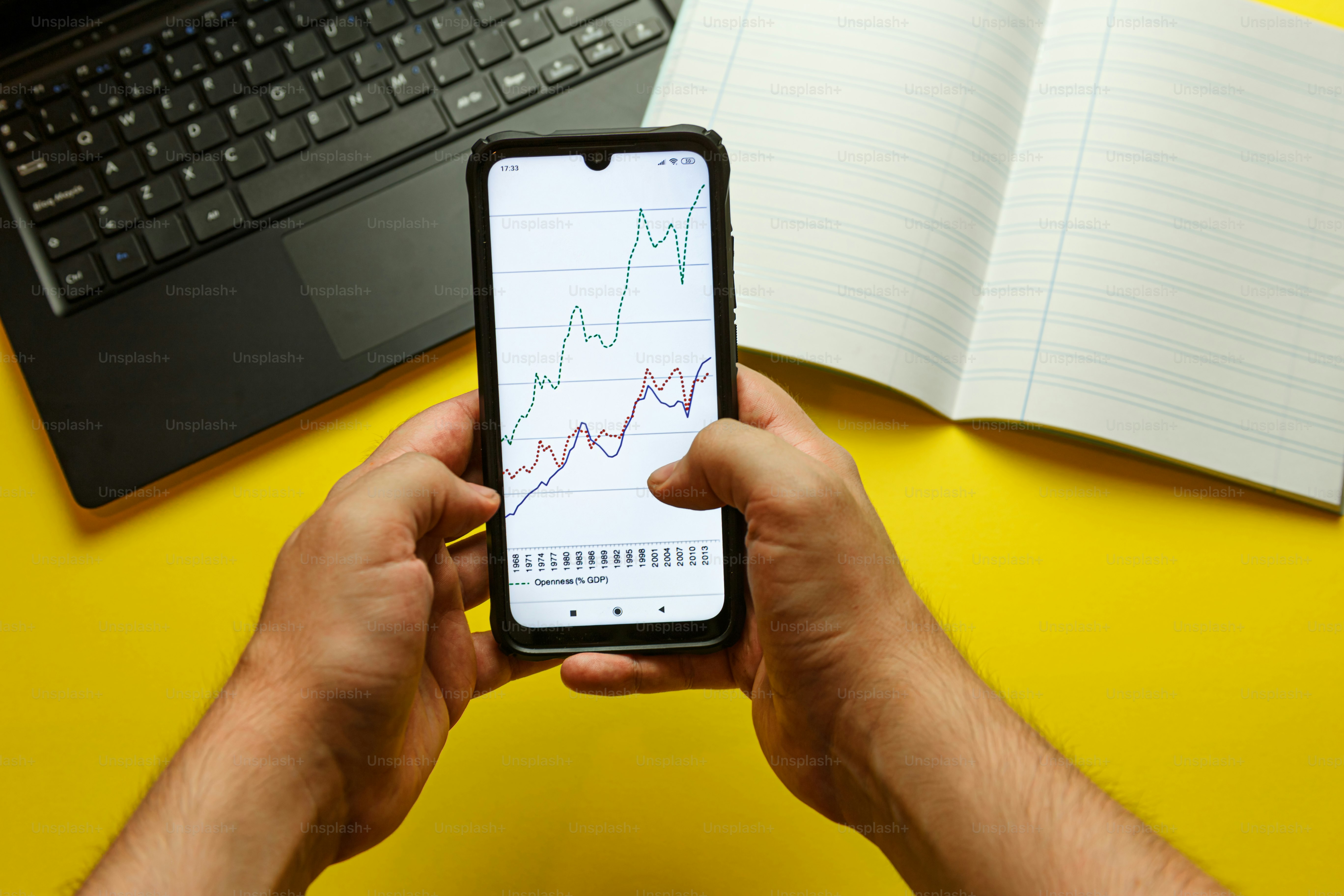 노트북 앞에서 휴대폰을 들고 있는 남자