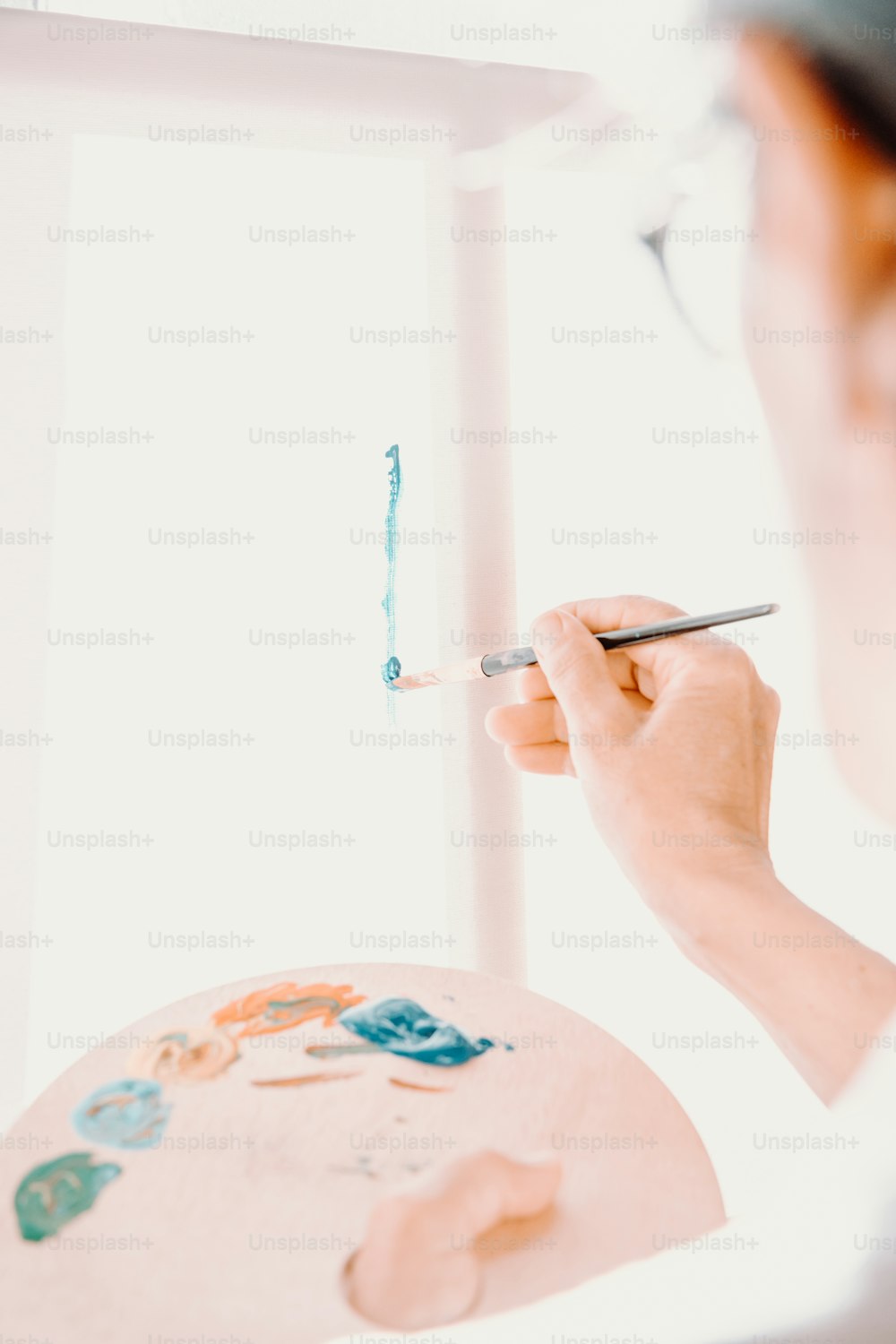 uma mulher está pintando um quadro com um pincel