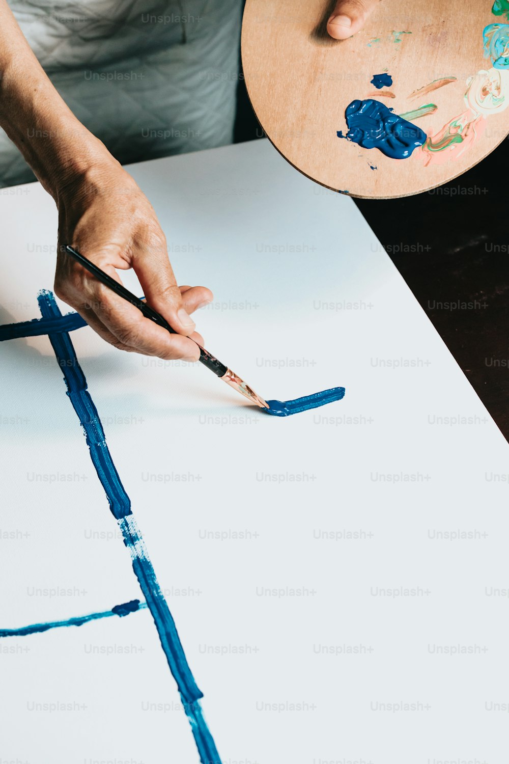 Eine Person malt ein Bild mit blauer Farbe