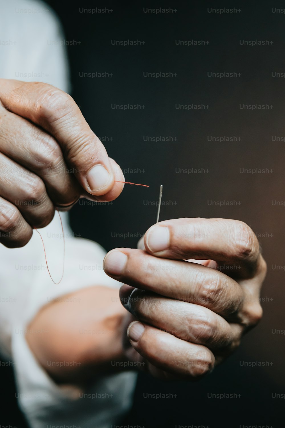 a person holding a thread in their hands
