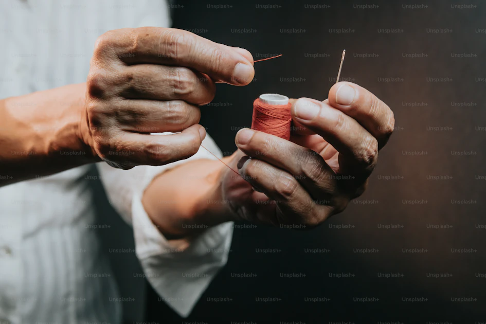 Two hands holding a thread and a needle photo – Needle and thread Image ...