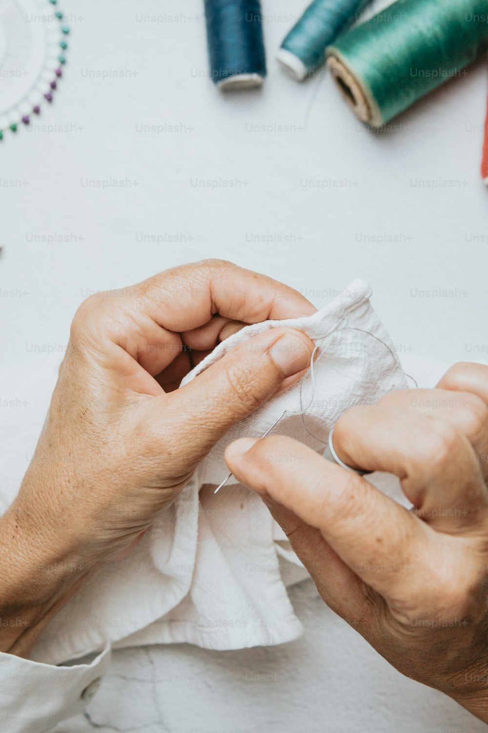 a person is sewing on a piece of cloth