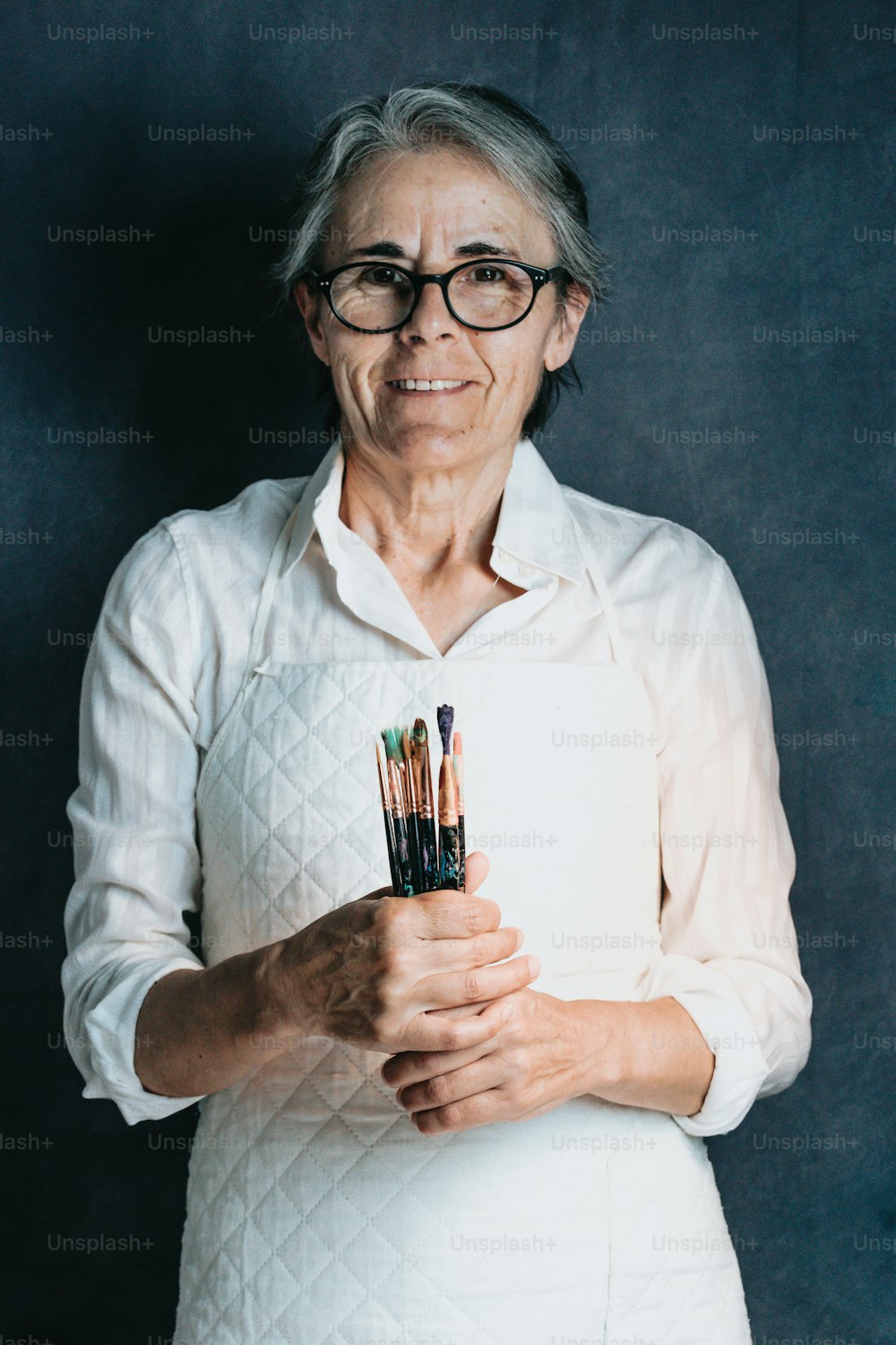 a woman holding a bunch of pencils in her hands