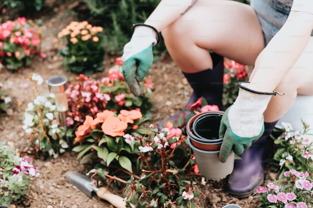 uma mulher em um jardim com luvas de jardinagem e ferramentas de jardinagem