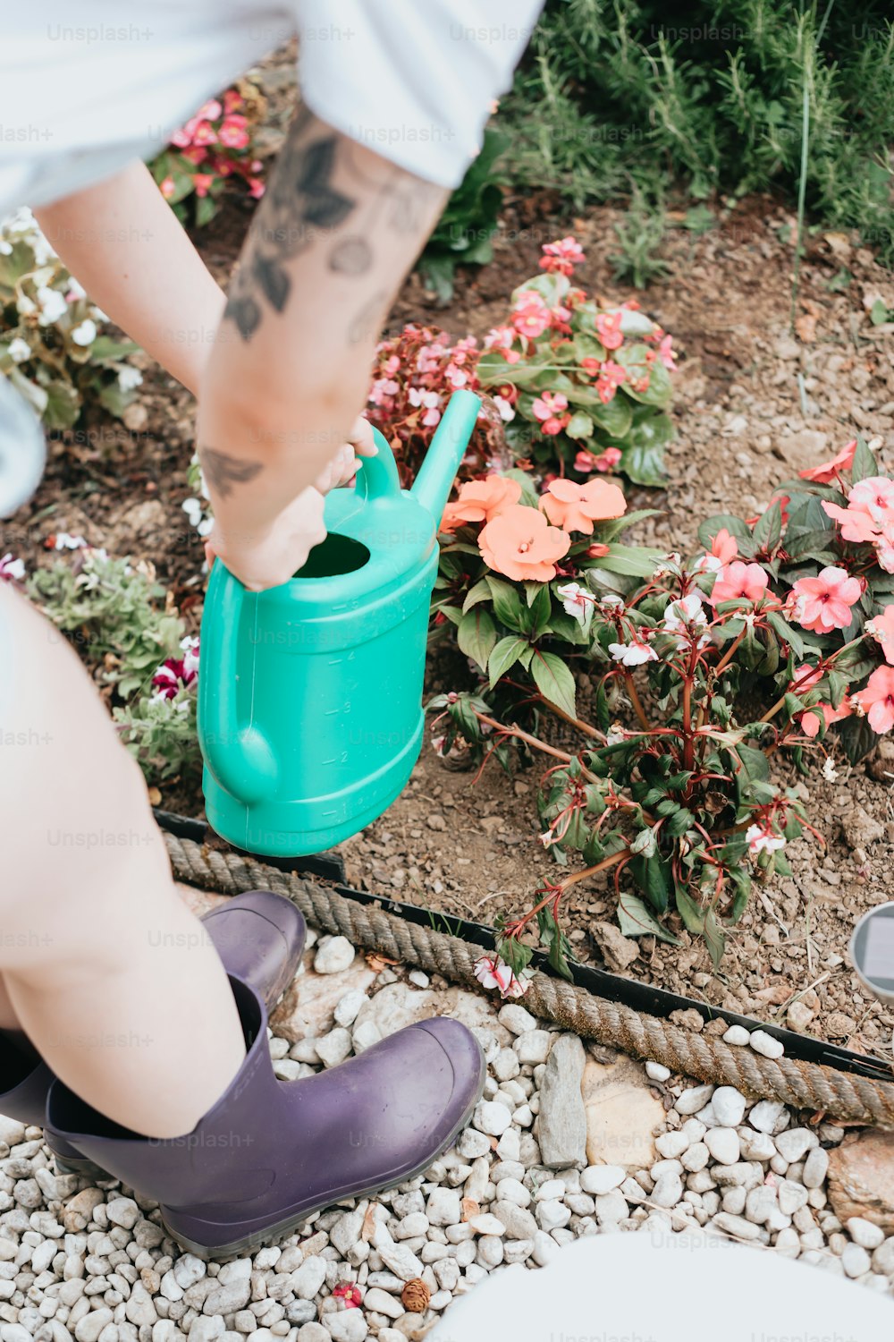 a person wearing purple shoes and a green watering can