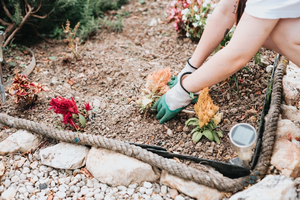 Una donna sta diserbando i fiori in un giardino