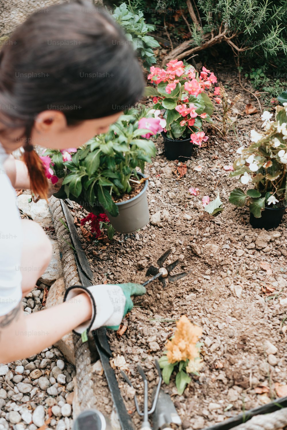 Una mujer trabajando en un jardín con flores