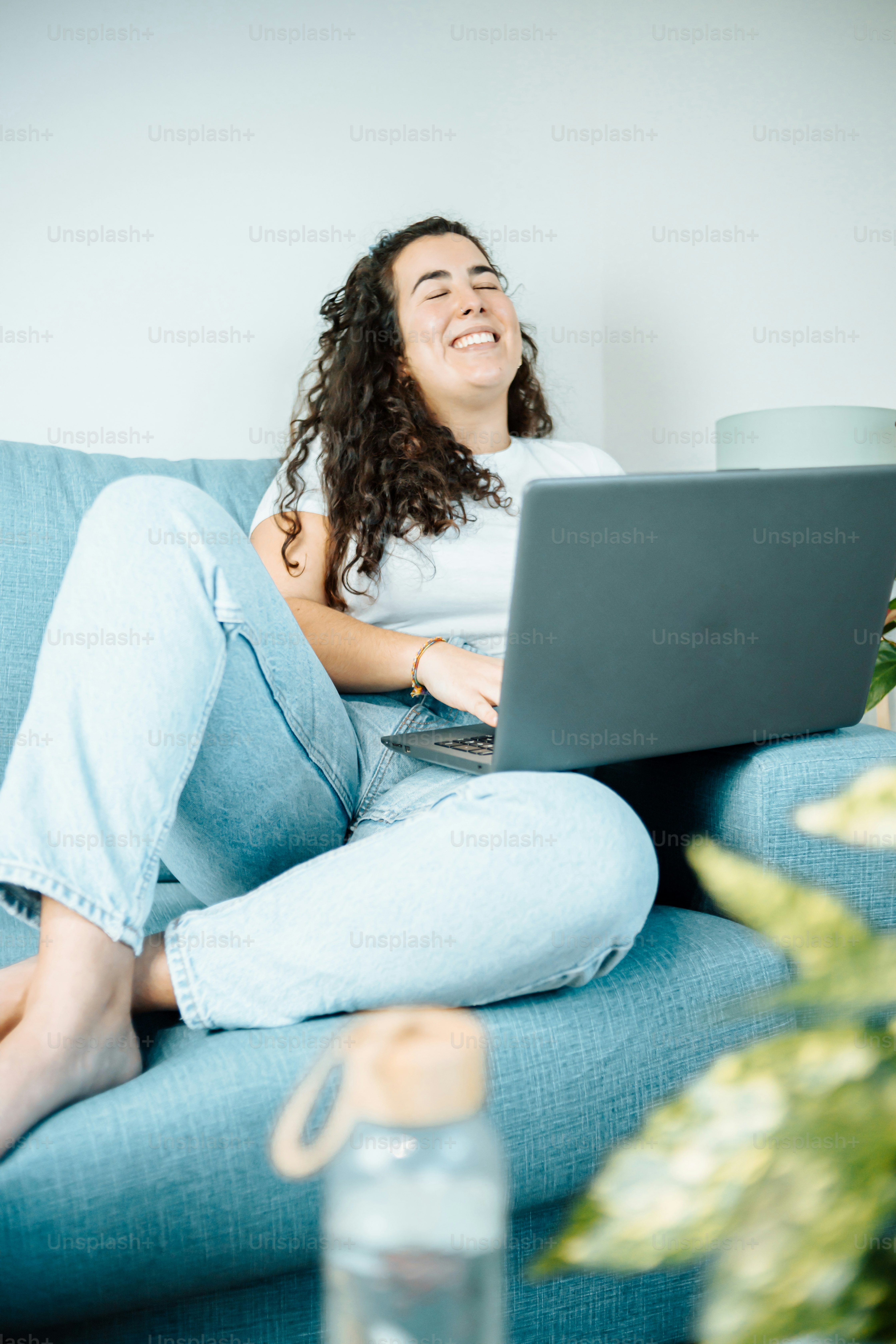 a woman sitting on a couch with a laptop