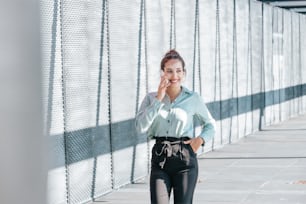 a woman standing on a sidewalk talking on a cell phone