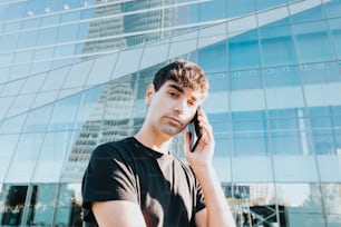 建物の前で携帯電話で話している若い男