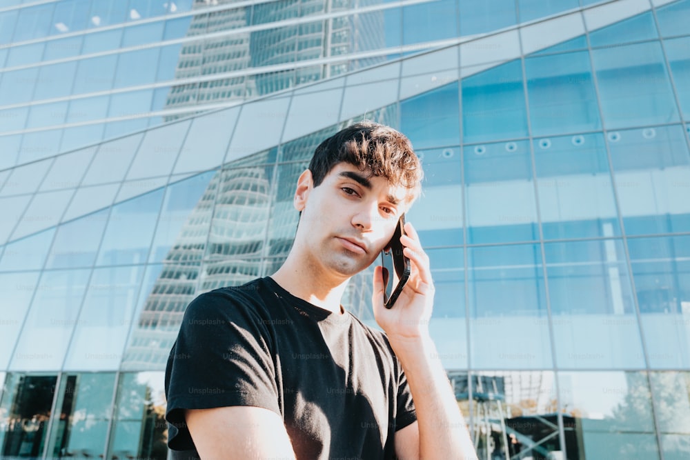 a young man talking on a cell phone in front of a building