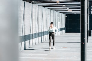 a woman walking down a sidewalk talking on a cell phone